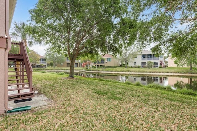 view of yard featuring a water view and stairs
