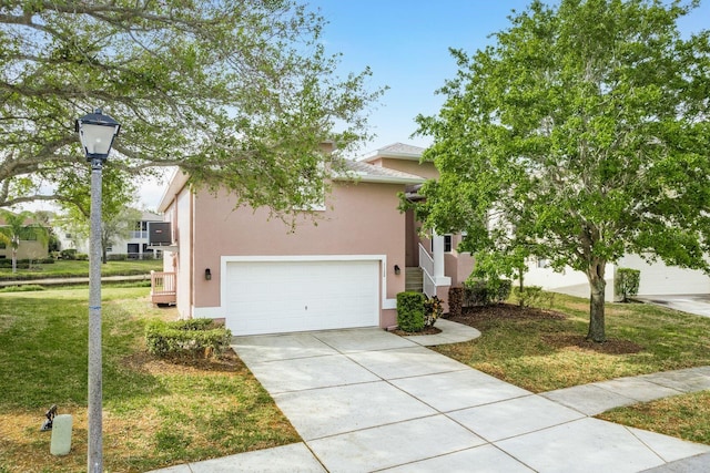 view of front of house with a front yard, driveway, and stucco siding