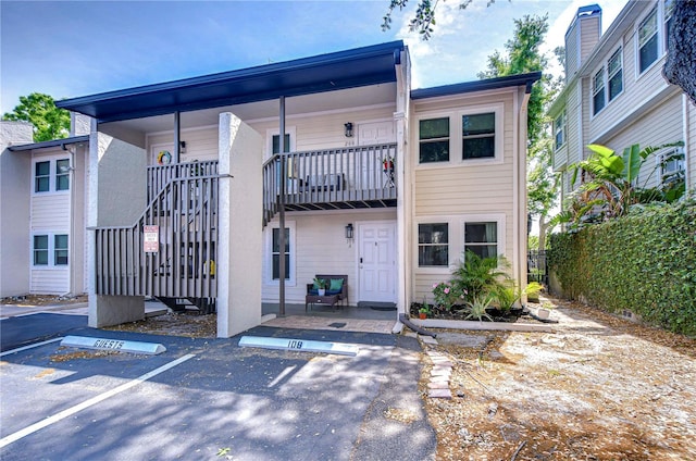 527 S Lincoln Ave Unit A108, Tampa, FL 33609 - back of house featuring uncovered parking and stairway