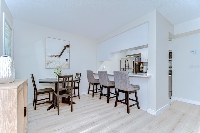 527 S Lincoln Ave Unit A108, Tampa, FL 33609 - dining space with baseboards, light wood-style flooring, and a textured ceiling