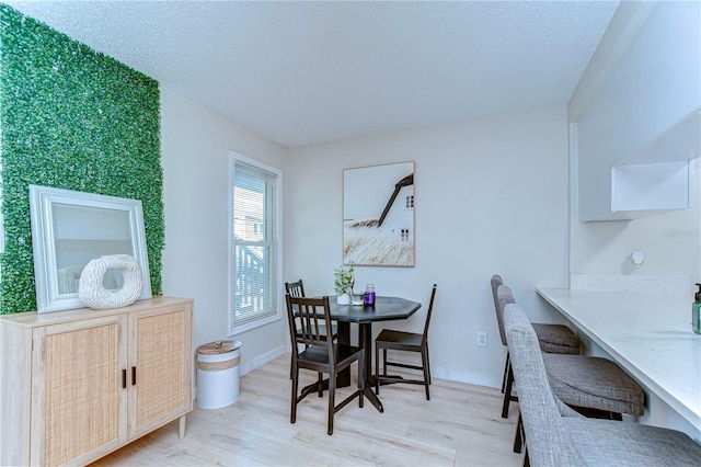 527 S Lincoln Ave Unit A108, Tampa, FL 33609 - dining area featuring baseboards, light wood-style floors, and a textured ceiling