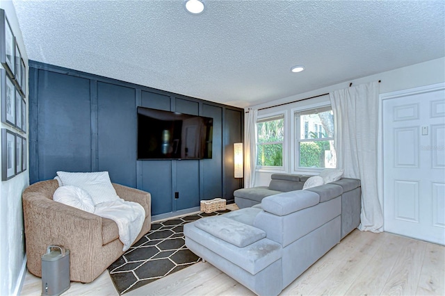 527 S Lincoln Ave Unit A108, Tampa, FL 33609 - living room with recessed lighting, light wood-style flooring, a decorative wall, and a textured ceiling