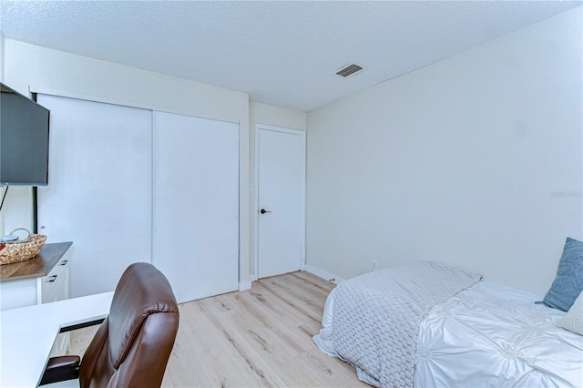 527 S Lincoln Ave Unit A108, Tampa, FL 33609 - bedroom featuring a closet, a textured ceiling, visible vents, and light wood-type flooring