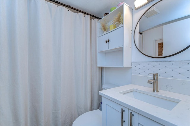 527 S Lincoln Ave Unit A108, Tampa, FL 33609 - full bathroom featuring visible vents, tasteful backsplash, toilet, and vanity