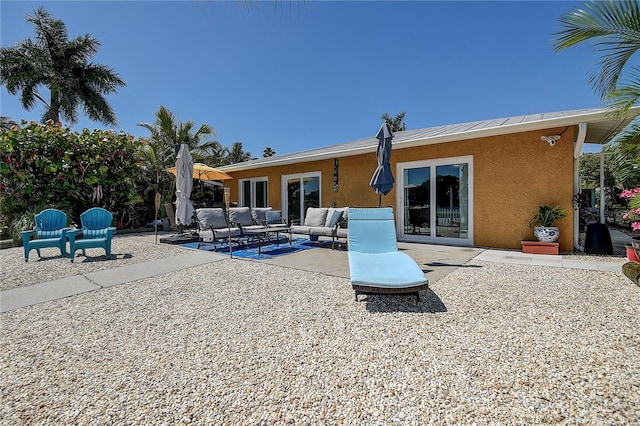 back of property with outdoor lounge area, stucco siding, and a patio area