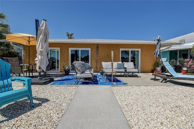rear view of property featuring stucco siding and a patio area