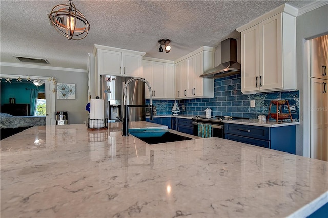 kitchen featuring light stone counters, stainless steel range with electric stovetop, wall chimney range hood, visible vents, and decorative backsplash