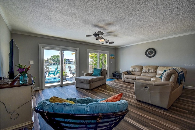 living area with baseboards, ornamental molding, wood finished floors, and a ceiling fan