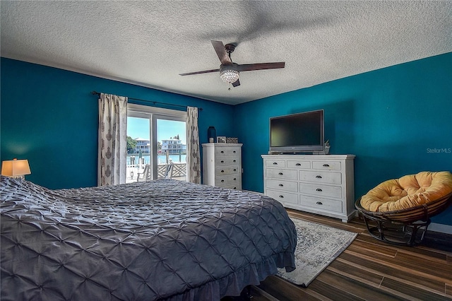bedroom with a textured ceiling, wood finished floors, ceiling fan, and access to outside