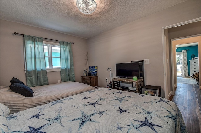 bedroom with a textured ceiling and wood finished floors