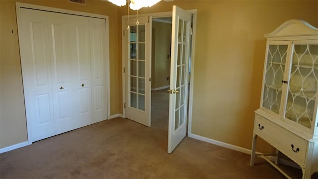2101 Fox Chase Blvd Unit 102, Palm Harbor, FL 34683 - unfurnished bedroom with french doors, carpet floors, baseboards, and a closet