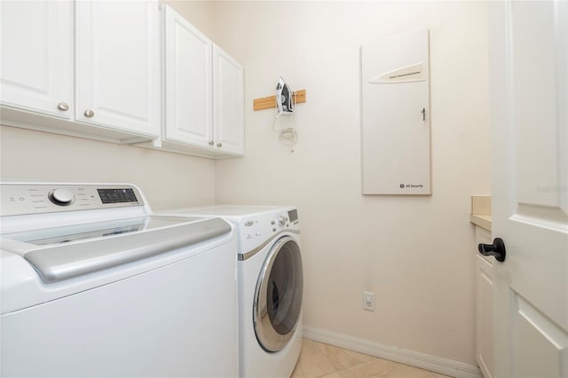 laundry room featuring baseboards, washer and dryer, cabinet space, and light tile patterned floors