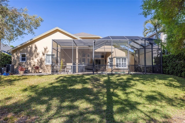 rear view of house featuring a lanai and a lawn