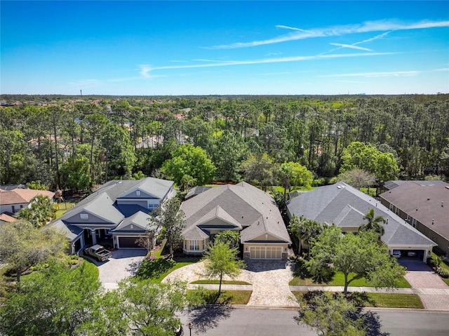 drone / aerial view featuring a residential view and a view of trees