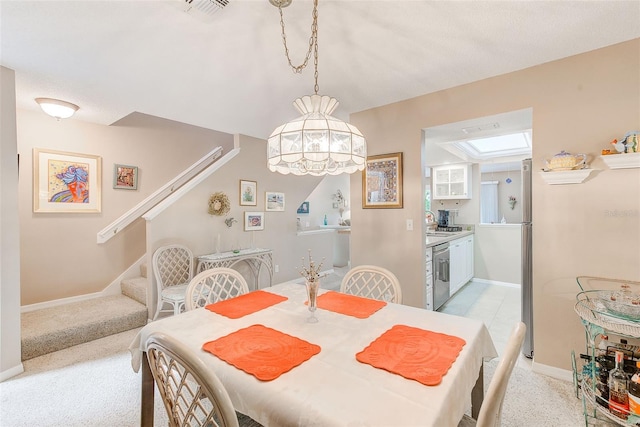 615 Garland Cir, Indian Rocks Beach, FL 33785 - dining space featuring stairway, a skylight, baseboards, and light colored carpet