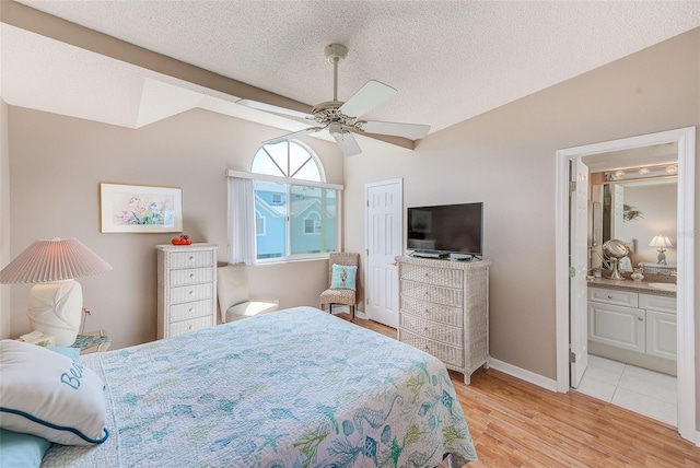 615 Garland Cir, Indian Rocks Beach, FL 33785 - bedroom with light wood-style flooring, lofted ceiling, ensuite bathroom, ceiling fan, and baseboards
