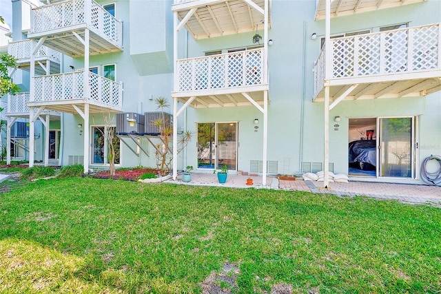 615 Garland Cir, Indian Rocks Beach, FL 33785 - back of house featuring a lawn, stucco siding, and central AC