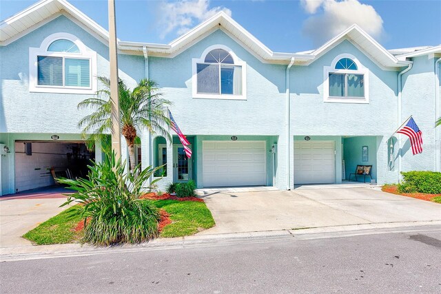 615 Garland Cir, Indian Rocks Beach, FL 33785 - townhome / multi-family property featuring a garage, driveway, and stucco siding
