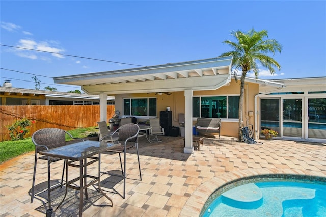 6667 28th St S, Saint Petersburg, FL 33712 - back of house featuring ceiling fan, fence, a fenced in pool, a patio, and stucco siding