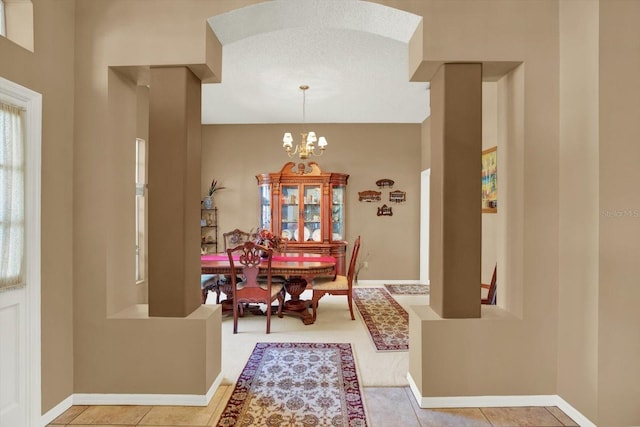 dining room featuring baseboards, a chandelier, and tile patterned flooring