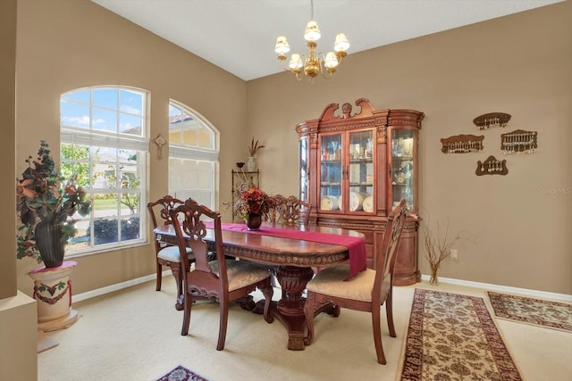 dining area with baseboards, light carpet, a notable chandelier, and plenty of natural light