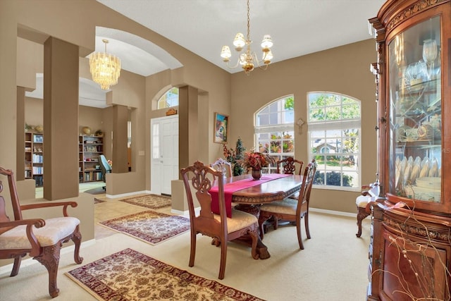dining space with arched walkways, baseboards, a notable chandelier, and light carpet