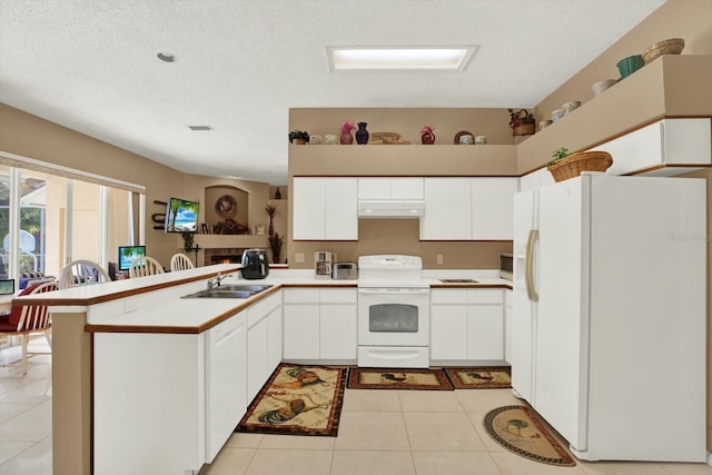kitchen with white cabinetry, white appliances, under cabinet range hood, a sink, and a peninsula