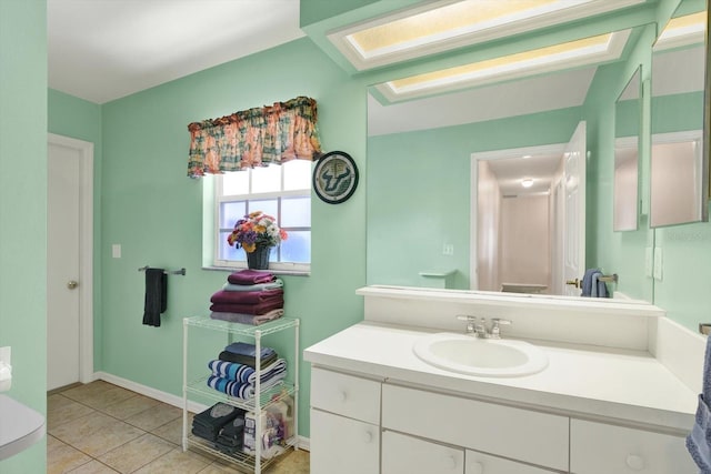 bathroom featuring baseboards, tile patterned floors, and vanity