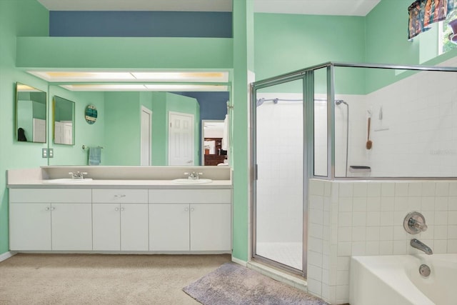 bathroom with double vanity, a sink, a garden tub, and a shower stall