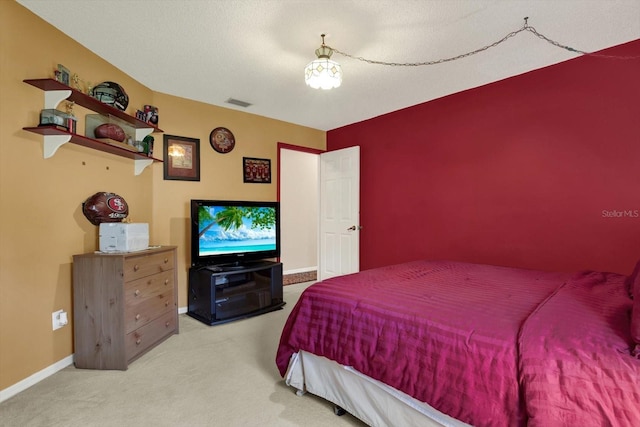 carpeted bedroom featuring baseboards, visible vents, and a textured ceiling