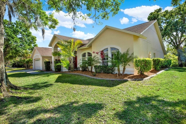 view of front of home with a front yard, an attached garage, and stucco siding