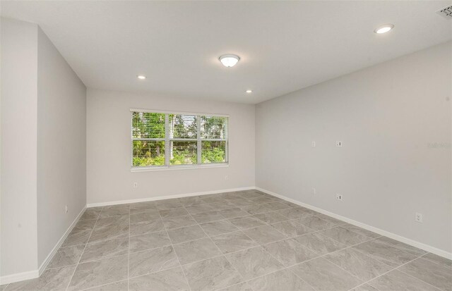 empty room featuring baseboards, recessed lighting, and visible vents