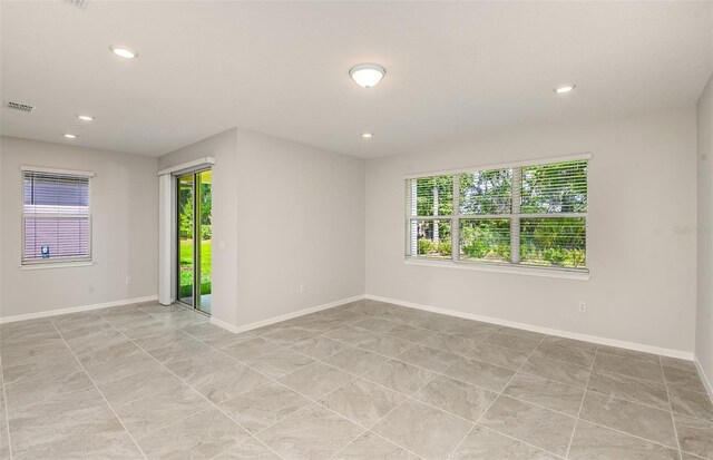 spare room featuring baseboards, plenty of natural light, recessed lighting, and visible vents