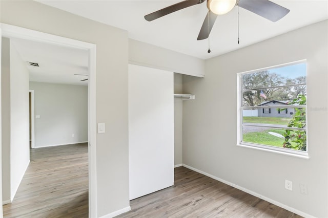 7711 Amherst St Unit A & B, Tampa, FL 33625 - unfurnished bedroom featuring wood finished floors, a closet, baseboards, and a ceiling fan