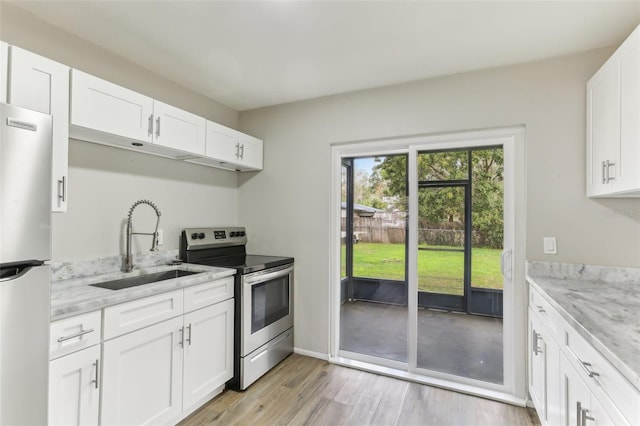 7711 Amherst St Unit A & B, Tampa, FL 33625 - kitchen with electric range, freestanding refrigerator, a sink, light wood-style flooring, and light stone counters