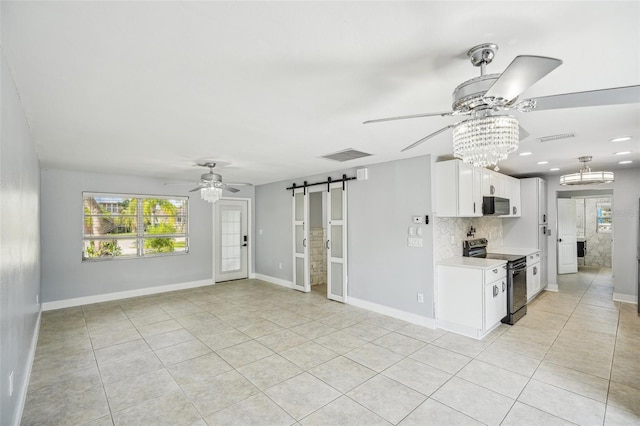 1832 Flamingo Dr, North Fort Myers, FL 33917 - unfurnished living room with a barn door, visible vents, and ceiling fan with notable chandelier