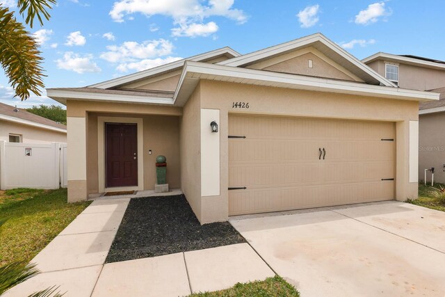 14426 Haddon Mist Dr, Wimauma, FL 33598 - view of front facade with a garage, concrete driveway, stucco siding, and fence