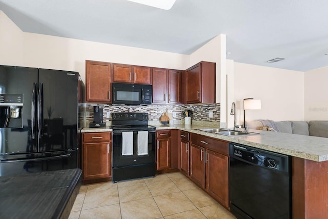 14426 Haddon Mist Dr, Wimauma, FL 33598 - kitchen featuring light countertops, a sink, visible vents, black appliances, and decorative backsplash