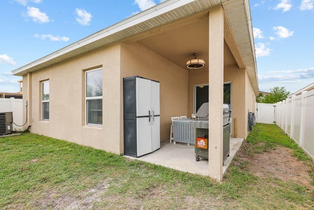 14426 Haddon Mist Dr, Wimauma, FL 33598 - back of property with a gate, a patio area, stucco siding, a fenced backyard, and a yard
