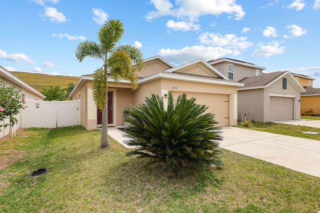 14426 Haddon Mist Dr, Wimauma, FL 33598 - view of front of property with a gate, an attached garage, concrete driveway, a front yard, and stucco siding