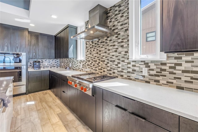 19816 Gulf Blvd Unit 201, Indian Shores, FL 33785 - kitchen featuring stainless steel appliances, light countertops, dark brown cabinets, and wall chimney exhaust hood