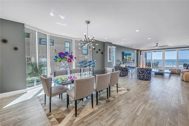 19816 Gulf Blvd Unit 201, Indian Shores, FL 33785 - dining space featuring light wood-style floors, expansive windows, a chandelier, a ceiling fan, and recessed lighting