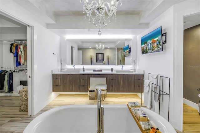19816 Gulf Blvd Unit 201, Indian Shores, FL 33785 - bathroom with an inviting chandelier, a sink, a freestanding bath, double vanity, and wood finished floors