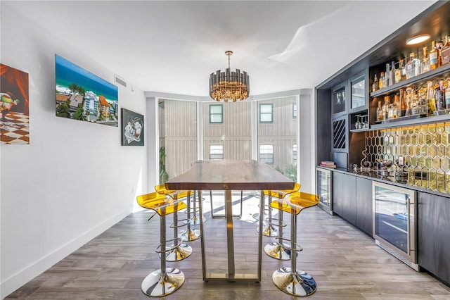 19816 Gulf Blvd Unit 201, Indian Shores, FL 33785 - bar featuring an inviting chandelier, visible vents, bar, and beverage cooler