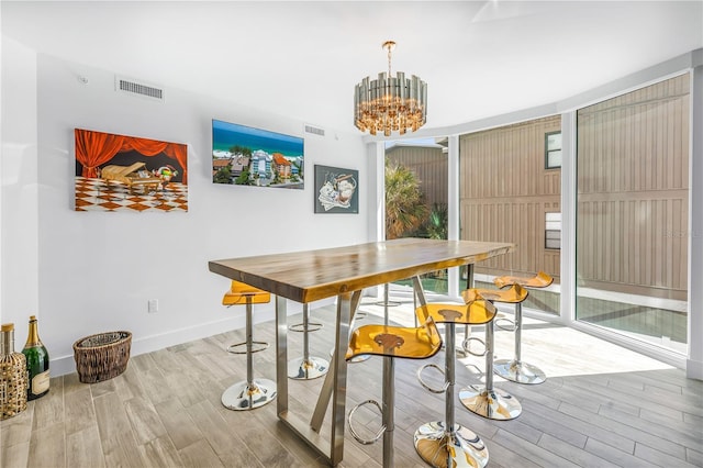 19816 Gulf Blvd Unit 201, Indian Shores, FL 33785 - dining area with visible vents, wood finished floors, baseboards, and a notable chandelier