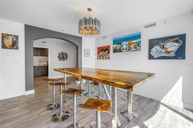 19816 Gulf Blvd Unit 201, Indian Shores, FL 33785 - dining space featuring arched walkways, baseboards, visible vents, and wood finished floors