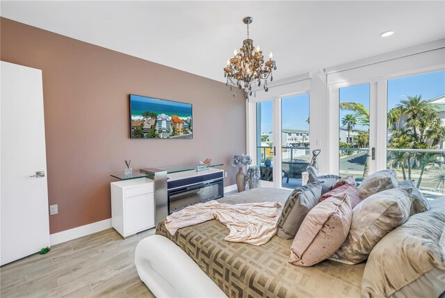 19816 Gulf Blvd Unit 201, Indian Shores, FL 33785 - bedroom featuring light wood-type flooring, recessed lighting, a chandelier, baseboards, and access to exterior
