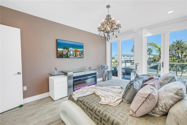 19816 Gulf Blvd Unit 201, Indian Shores, FL 33785 - bedroom featuring recessed lighting, baseboards, an inviting chandelier, light wood-style floors, and access to exterior