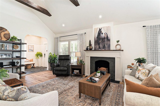 2910 W Aquilla St, Tampa, FL 33629 - living area with beam ceiling, wood finished floors, high vaulted ceiling, arched walkways, and a fireplace