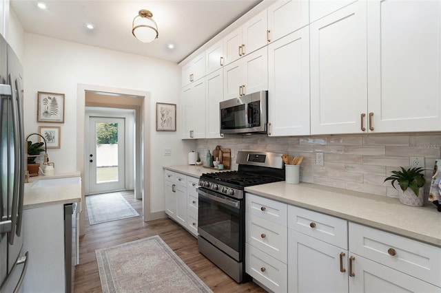 2910 W Aquilla St, Tampa, FL 33629 - kitchen with stainless steel appliances, decorative backsplash, light countertops, wood finished floors, and recessed lighting